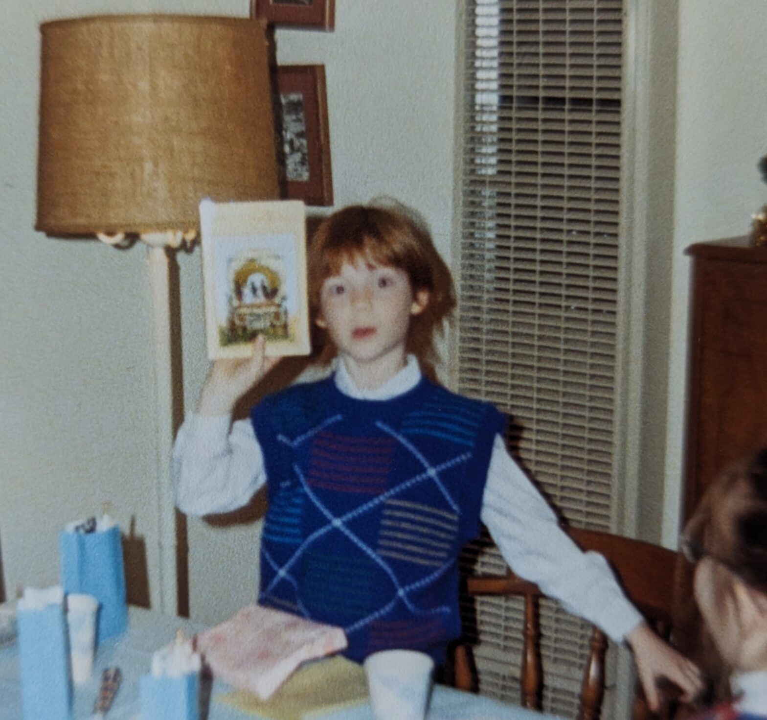 Fifth-grade Elayne holds up a copy of Little House on the Prairie, looking jazzed